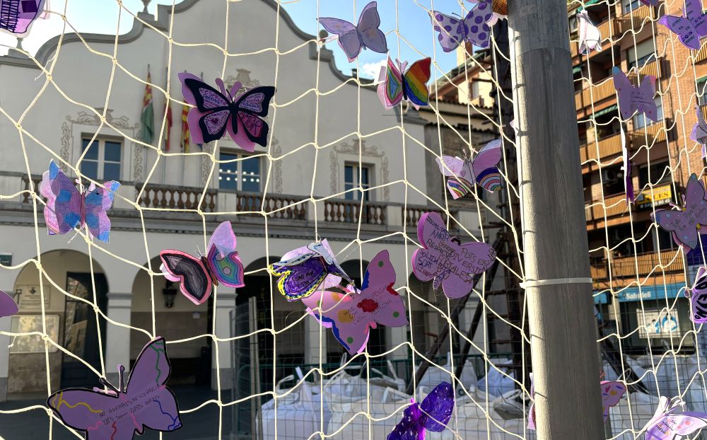 Xarxa de papallones liles col·locada als pals de banderes de la pl Francesc Layret