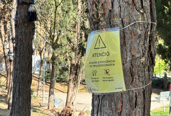 Zona amb un cartell avisant de la possible presència d'eruga processionària
