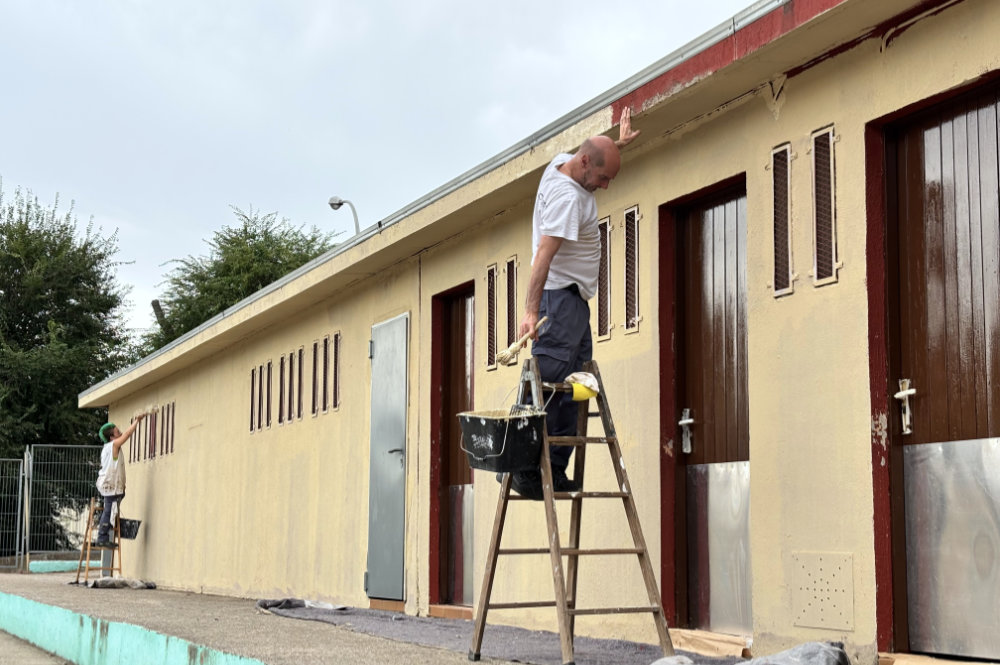 Operaris pintant façana pati escola Xarau