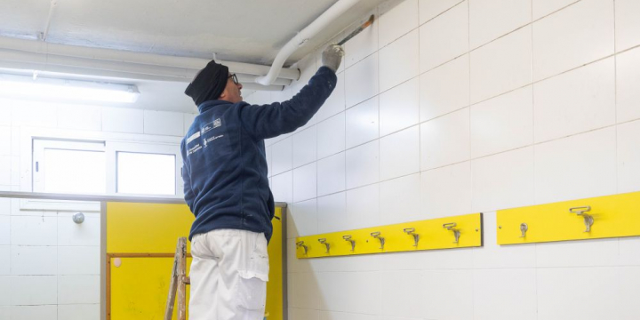 Pintor treballant en un pla d'ocupació a la zona esportiva de La Bòbila