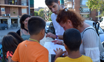 David González i Carme Arché ajudant a un grup d'infants a desxifrar el mapa