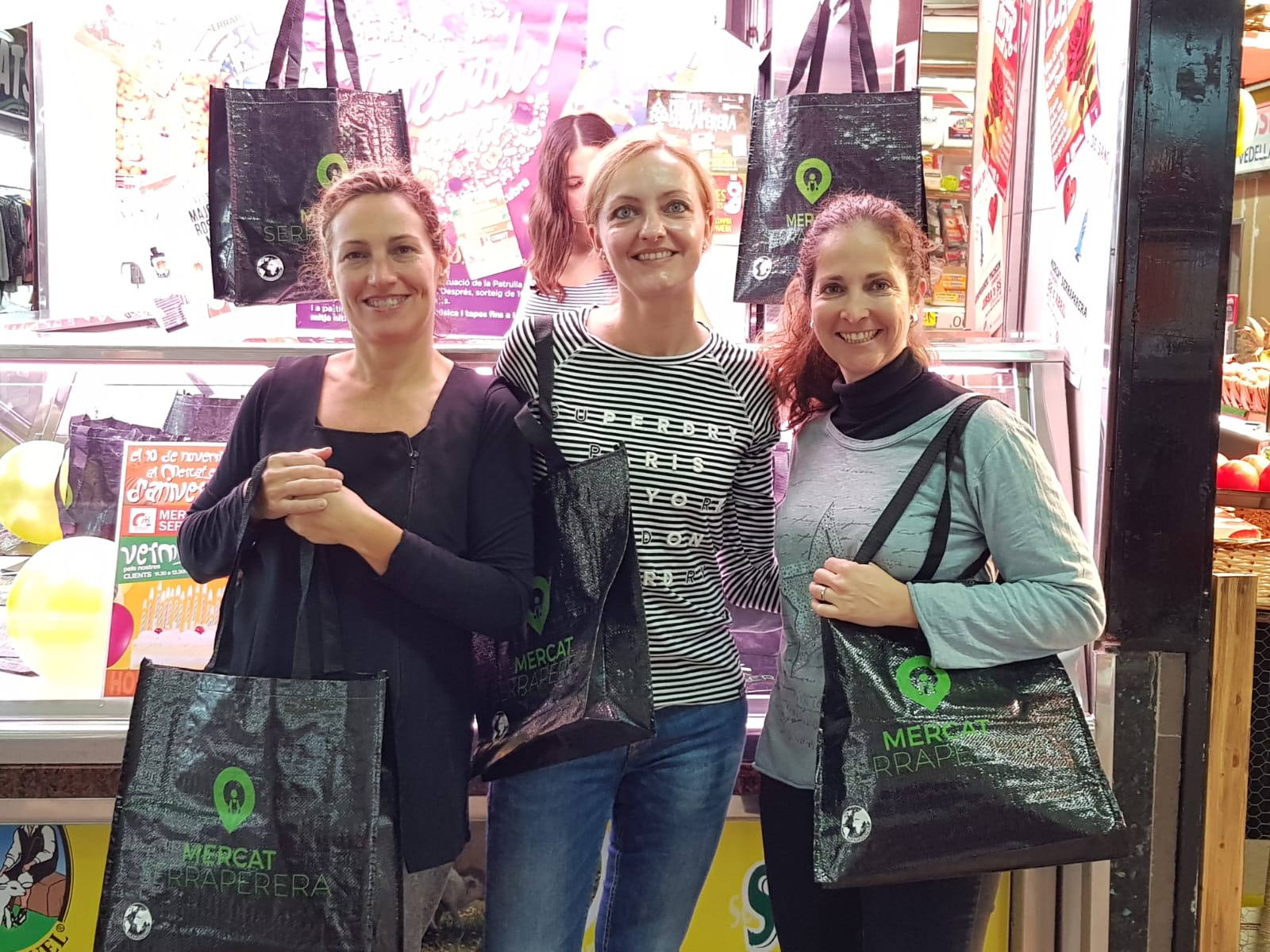 La regidora d e Promoció Econòmica, Contxi Haro (centre) acompanyada de la presidenta Inma Jodas i la vocal Meryl Albarran amb les bosses del mercat