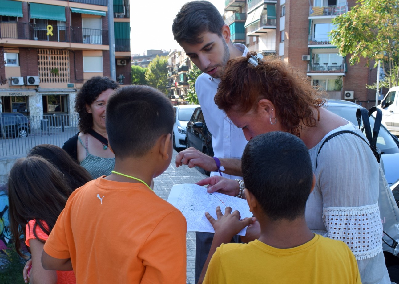 David González i Carme Arché ajudant a un grup d'infants a desxifrar el mapa