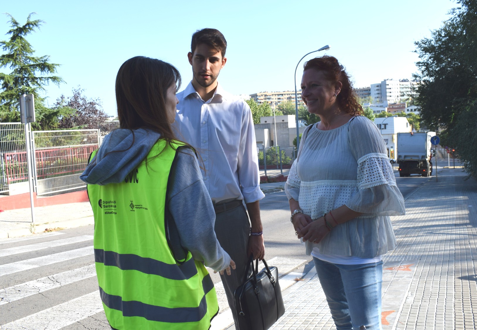 Agent cívica conversant amb els regidors David González i Carme Arché