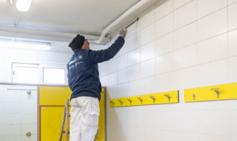 Pintor treballant en un pla d'ocupació a la zona esportiva de La Bòbila